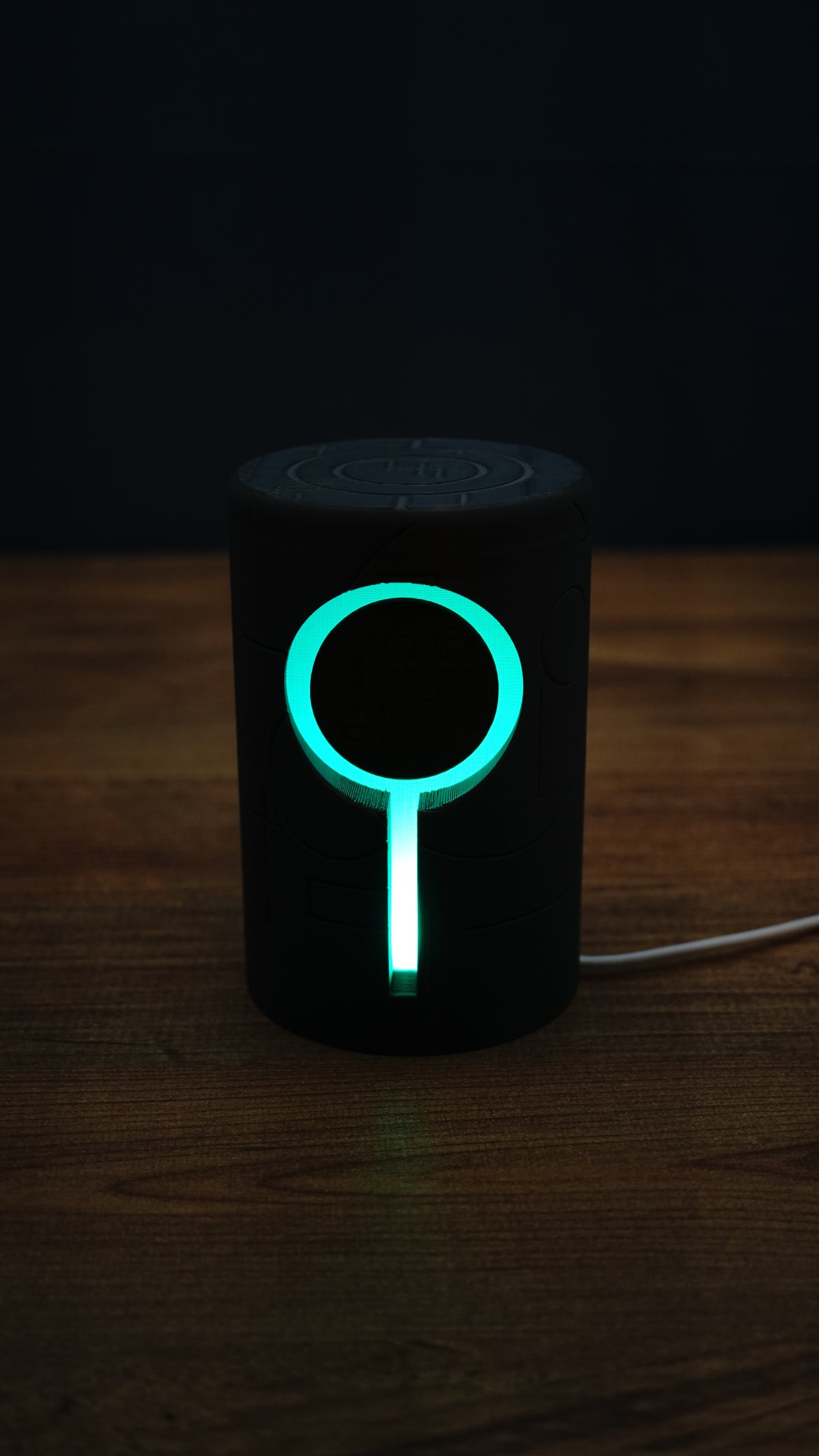 No Man’s Sky inspired Knowledge Stone lamp glowing bright cyan in a dark room, highlighting the circular RGB ring and vertical light strip.