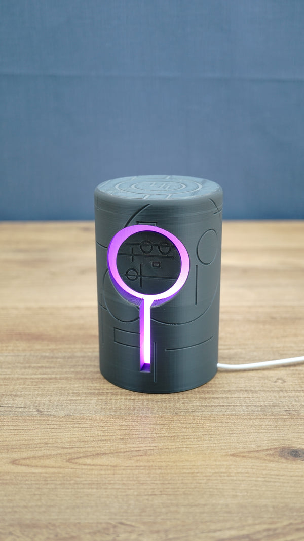 Knowledge Stone RGB LED gaming light illuminated purple around the circular centre and vertical light channel on a dark grey sci-fi body.