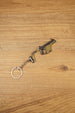Angled KRISS Vector style SMG keyring on wood showing olive green and black details, a compact collectible for tactical shooter gamers
