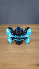 Front view of the large Duskwing Butterfly figure with a dark-blue body, curved blue antennae and patterned blue-and-gold wings.