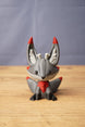 Large Obsidian Kitsuu fox figure front view with grey colouring, red chest accent, black paws and tall pointed ears
