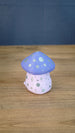Back view of the Madrinas Fun Guy figurine showing silver spots and star markings on its pale pink body beneath a lavender cap.