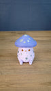 Front view of a Madrinas Fun Guy figurine with a lavender mushroom cap, silver spots, orange eyes, and a pale pink body.