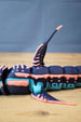 Detailed side close-up of Marrowbreach inspired figure showing dorsal fin, fins, body segments, coral red stripes and light blue lower panels.