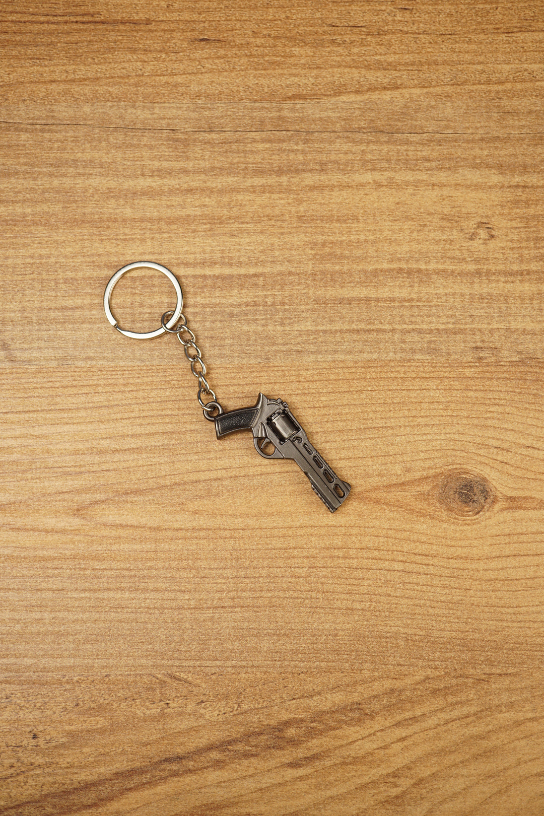 Miniature Rhino-style .357 revolver keyring with chain and silver ring, displayed on wood as a collectible FPS game accessory