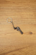 Miniature Rhino-style .357 revolver keyring with chain and silver ring, displayed on wood as a collectible FPS game accessory