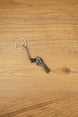 Miniature Rhino-style .357 revolver keyring with chain and silver ring, displayed on wood as a collectible FPS game accessory