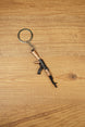 AK-74 style rifle keychain with metal ring and chain on wooden table, tactical gaming accessory for FPS and shooter fans