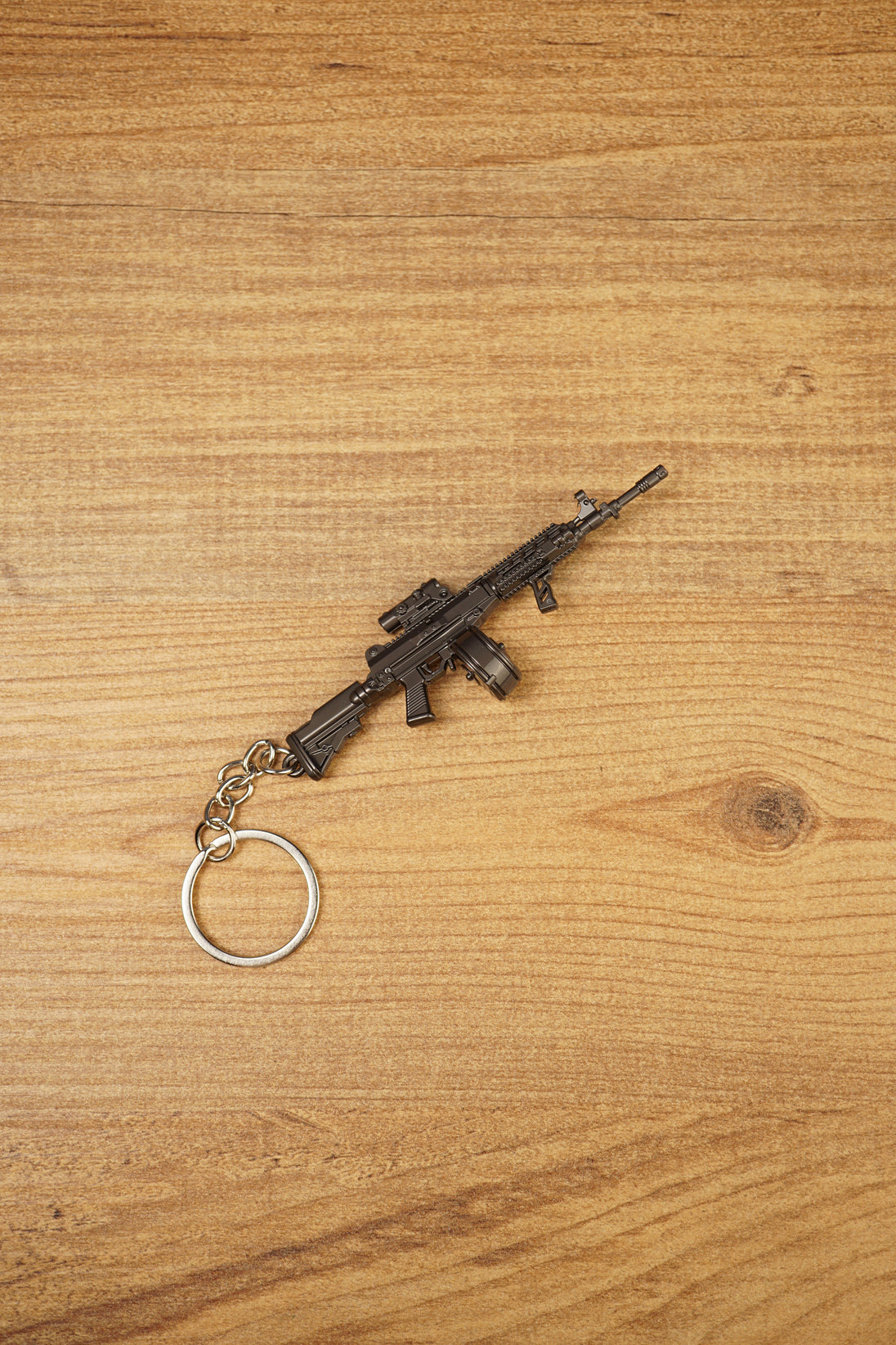 Close-up of miniature AK-12 rifle keyring showing metal finish, drum magazine, tactical rail details and compact collectible size