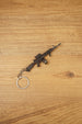 Close-up of miniature AK-12 rifle keyring showing metal finish, drum magazine, tactical rail details and compact collectible size