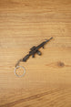 Close-up of miniature AK-12 rifle keyring showing metal finish, drum magazine, tactical rail details and compact collectible size