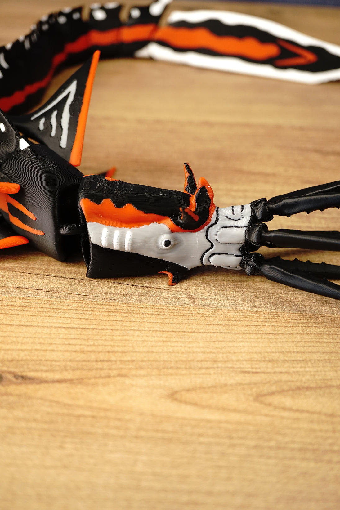 Detailed side close-up of the Needler Mango creature model, highlighting its white facial armour, orange crest, black jaw and moving mouth mechanism.