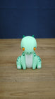 Front view of Nibbles the Drake Palia collectible figure with mint green body, orange eyes, white belly, dark green horns and spotted markings