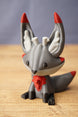 Close-up of Obsidian Kitsuu collectible with grey face, red accents, white inner ears and cute fox-inspired expression