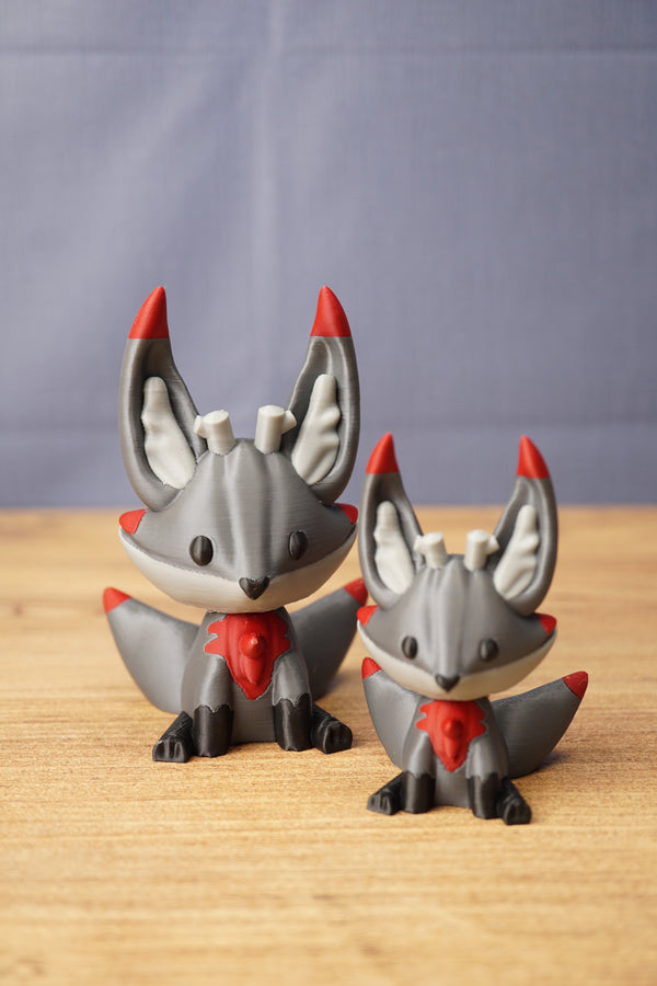 Obsidian Kitsuu figures in large and small sizes with grey bodies, red accents, black paws and cute fox-like faces