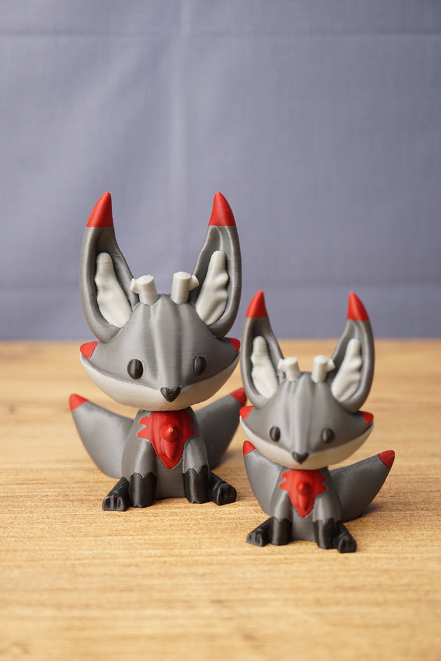 Obsidian Kitsuu figures in large and small sizes with grey bodies, red accents, black paws and cute fox-like faces