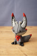 Obsidian Kitsuu fox figure seated front view with grey body, red ear tips, red chest detail and fantasy creature styling