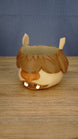 Front angled view of a Palia-inspired Ormuu Shack ice cream tub holder with brown fringe, cream face, pointed ears, orange muzzle and white teeth.