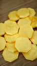 Pile of RuneScape inspired gold coins spread across a wooden surface, showing multiple OSRS GP collectibles with raised emblem details