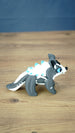 Side view of a Palia Bluebristle Muujin figurine with vivid blue eyes, grey legs, oversized ears, white spiky mane and decorative turquoise blue details.