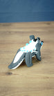 Rear view of the Palia Bluebristle Muujin collectible figure displaying its long grey and white tail, white fantasy creature mane and turquoise blue accents.