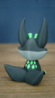 Back view of a Cave Kitsuu 3D printed figure showing its curled tail, tall ears, and bright green diamond markings on its back.