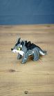 Side view of the classic Palia Muujin plush-inspired figure featuring yellow eyes, upright ears, grey legs, black back spikes and a long detailed tail.
