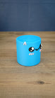 Angled side view of the blue Palia Cyl Cylinder Collectible showing its rounded cylindrical shape and cute face.