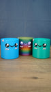 Blue Palia Cyl Cylinder Collectible displayed with the rainbow and green Cyl color versions on a wooden tabletop.