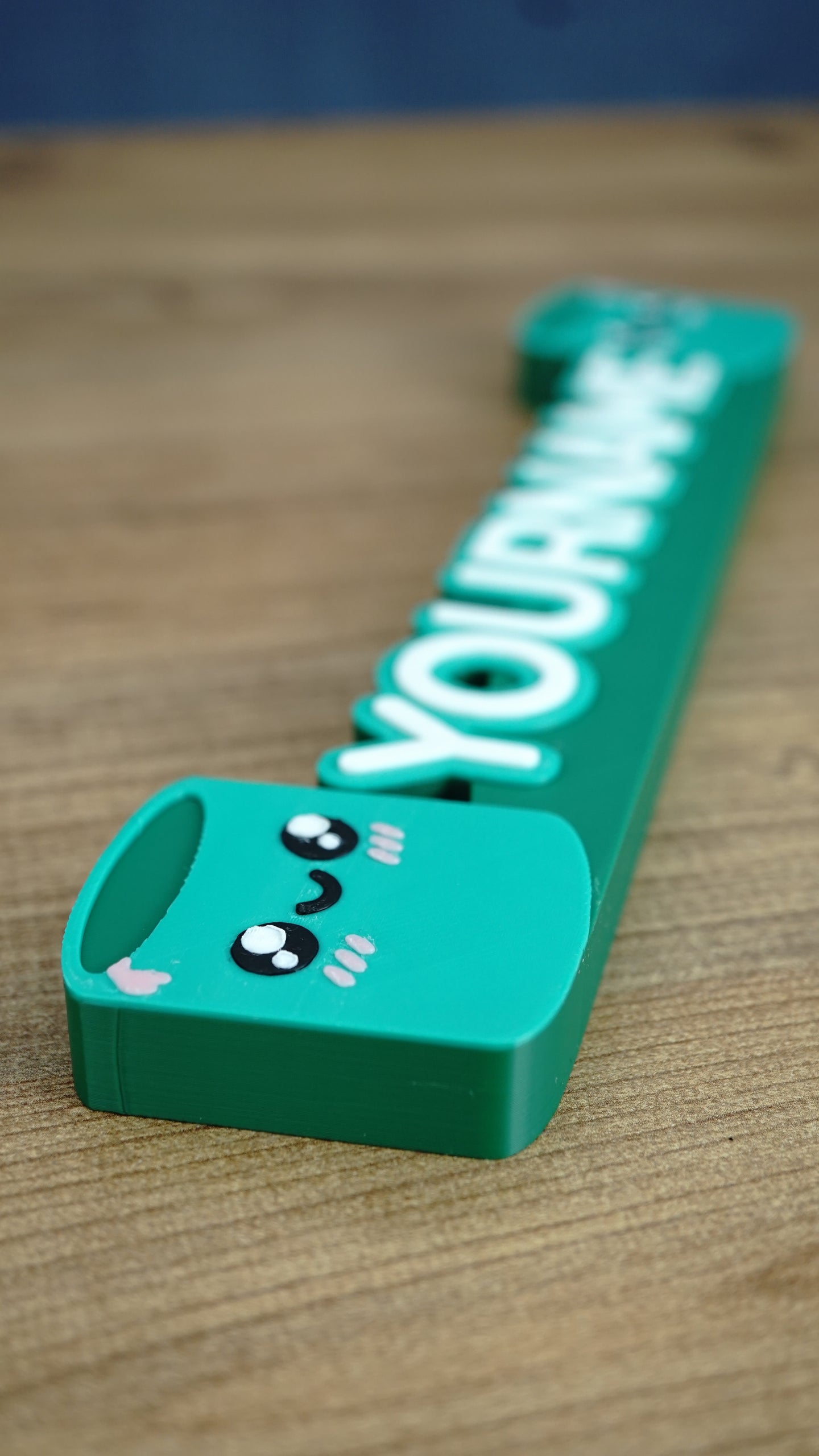 Detailed side view of Palia Cyl-inspired personalized nameplate showing cute character face, layered lettering and green gaming desk sign design
