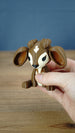 Hand holding the Elder Sernuk-inspired Palia plush figure to show its size and detailed face.