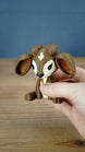Hand holding the Elder Sernuk-inspired Palia plush figure to show its size and detailed face.