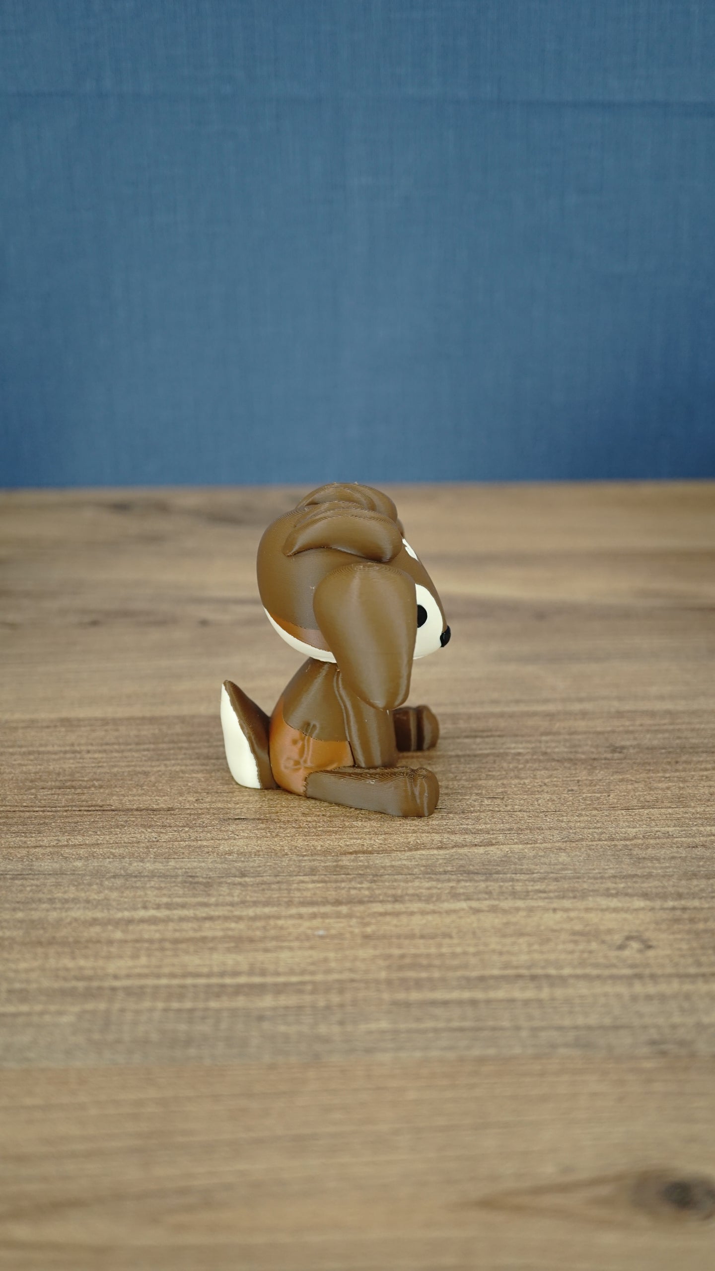 Profile view of the Elder Sernuk-inspired plush figure with brown body, cream face, and small tail