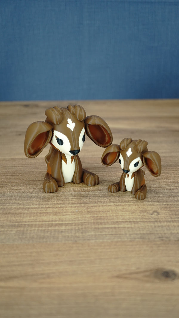 Large and small Elder Sernuk-inspired Palia plush figures displayed together on a wooden tabletop.