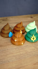 Palia-inspired fertilizer collectible set showing five colourful designs including brown, green and pale green figures with decorative details.
