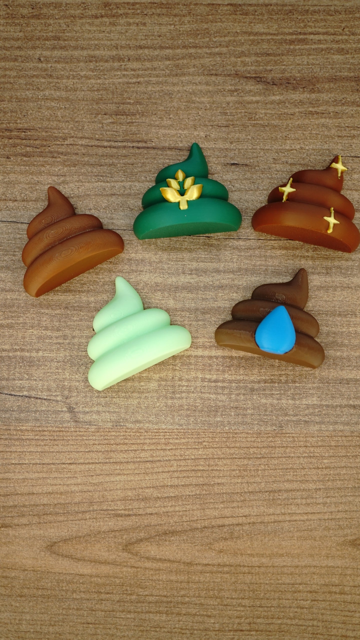Five Palia fertilizer magnet designs arranged on a wooden surface, including WeedBlock, QualityUp, SpeedyGro, HydratePro and HarvestBoost styles.