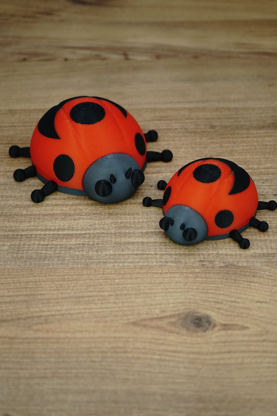 Palia Garden Ladybug Plush collectibles in 11cm and 8cm sizes, showing red and black ladybug designs together on a wooden display surface.