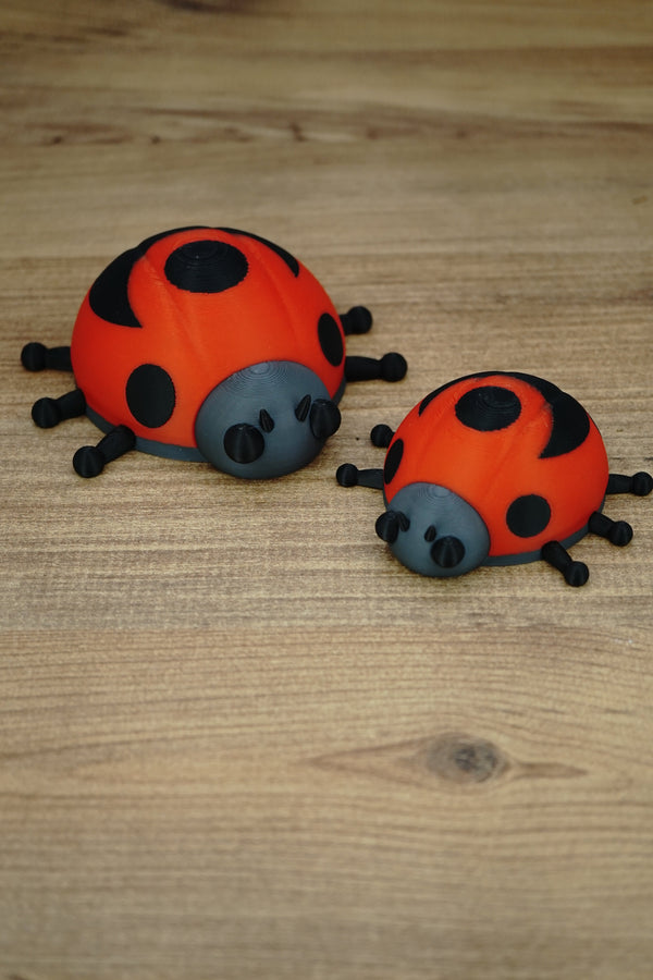 Palia Garden Ladybug Plush collectibles in 11cm and 8cm sizes, showing red and black ladybug designs together on a wooden display surface.