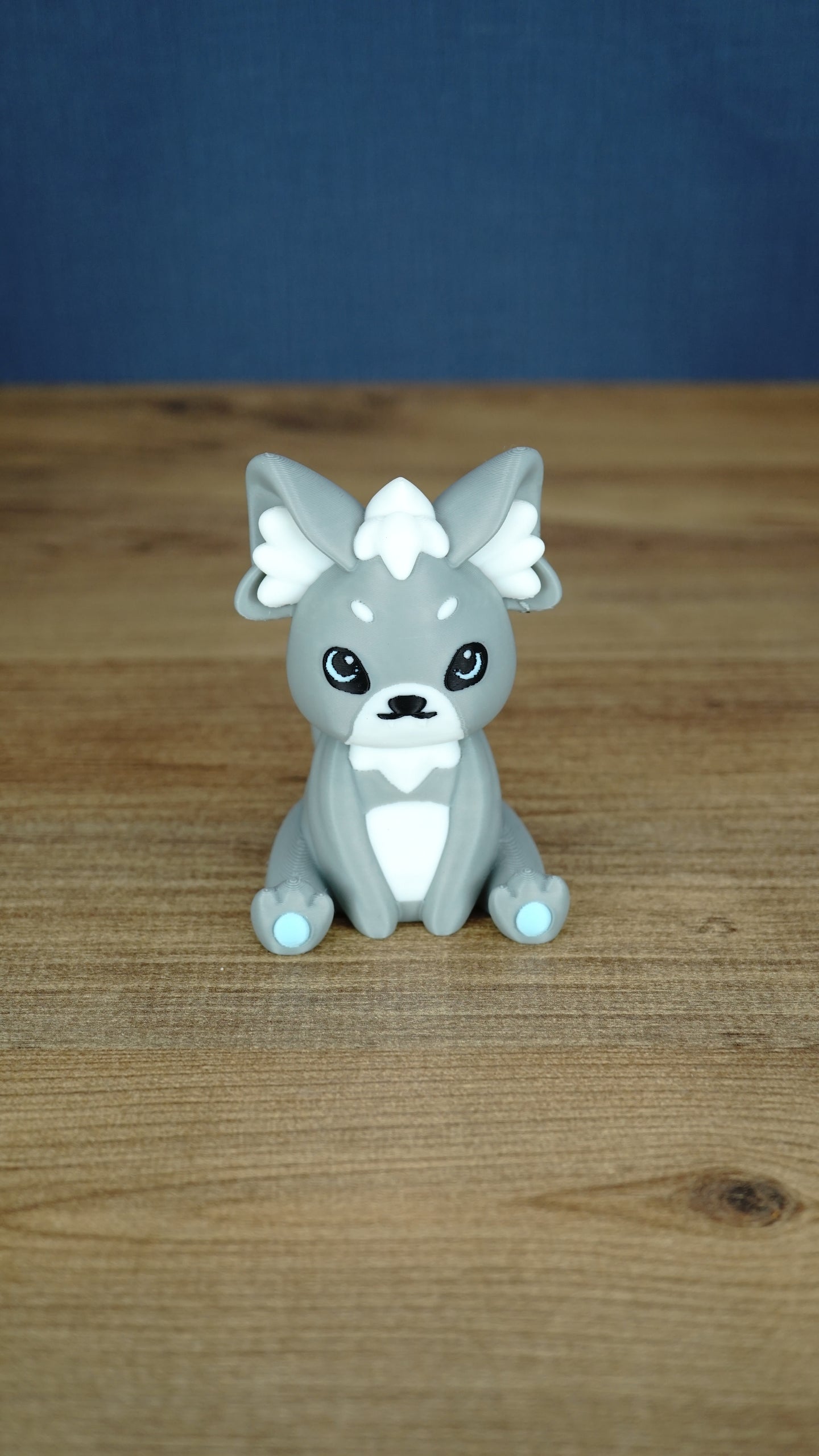 Front view of a grey 3D printed Palcat plush figure with white ear tufts, black eyes, white chest detail, and light blue paw pads.