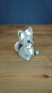 Side view of a grey 3D printed Palcat plush figure showing large ears, white ear tufts, black eyes, and a curled white-tipped tail.