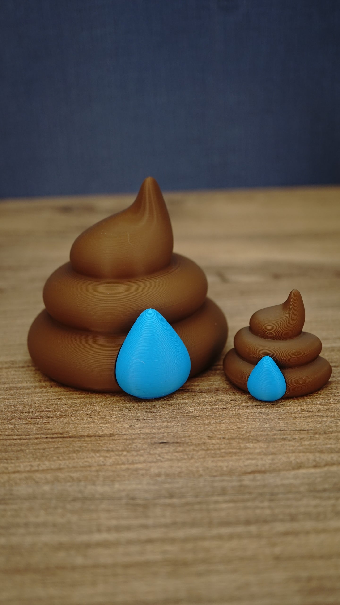 Large and small HydratePro Palia fertilizer collectibles in brown with bright blue water-drop details, showing figure and magnet size styles.