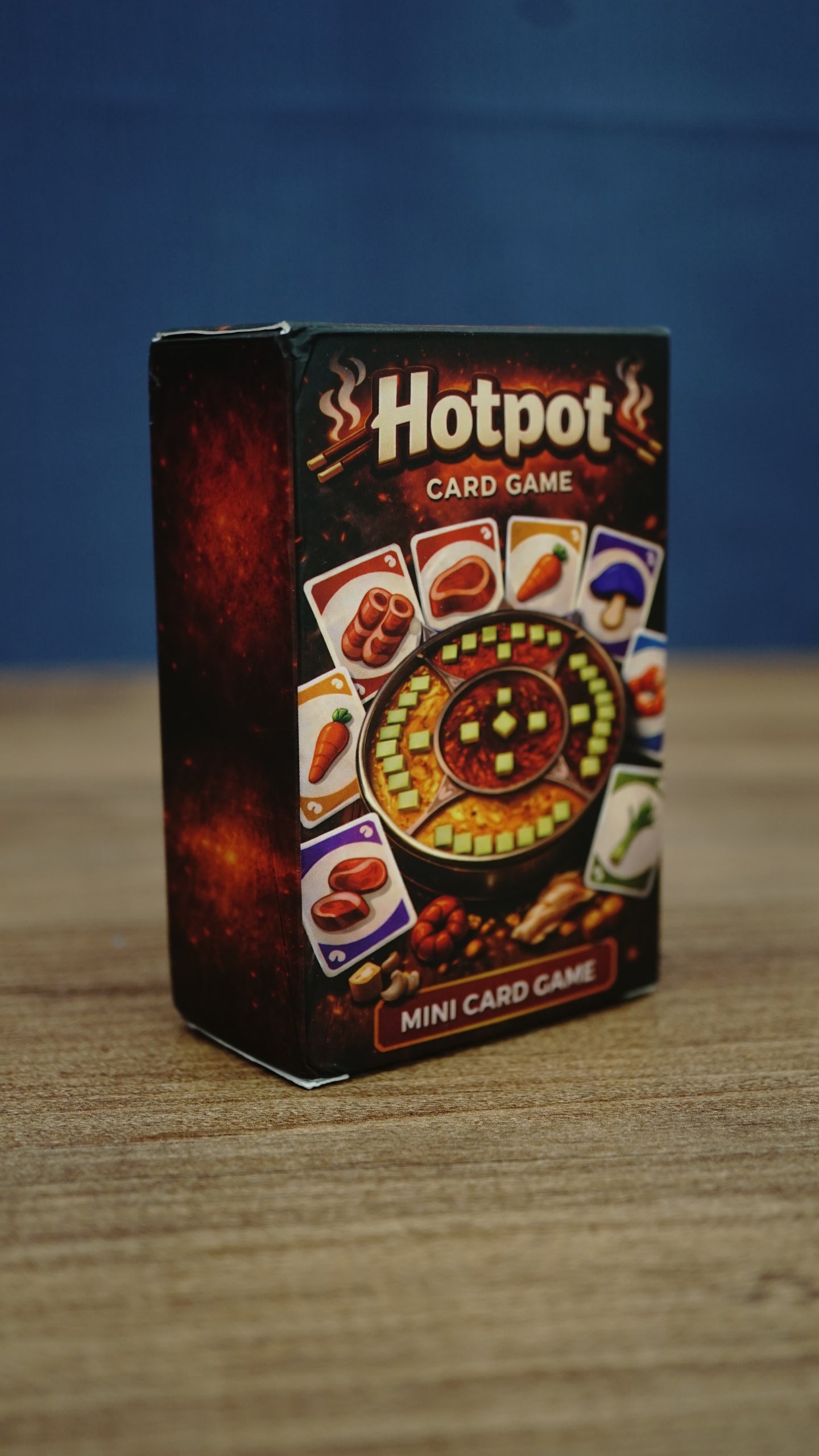 Angled view of the Palia-inspired Hotpot card game box showing the illustrated front design, ingredient cards, and dark red side panel.
