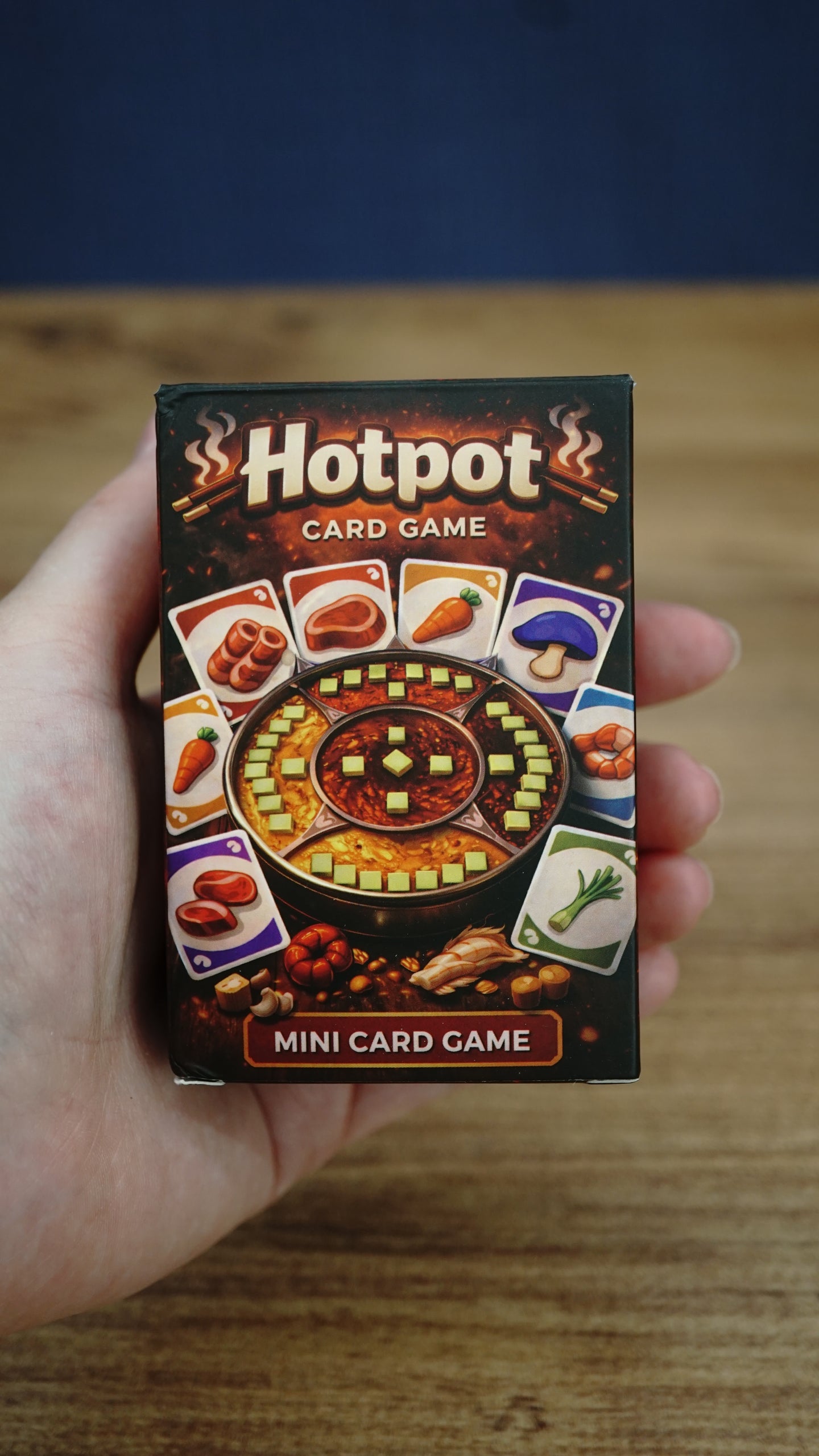 Compact Palia-inspired Hotpot card game box held in hand to show the portable size, detailed artwork, and mini card game packaging.