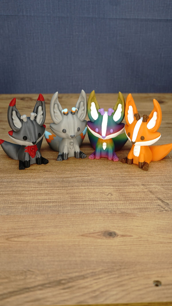 Close-up group photo of four Palia Kitsuu figure variants, including Obsidian, Caldera, Rainbow, and Ancient styles.