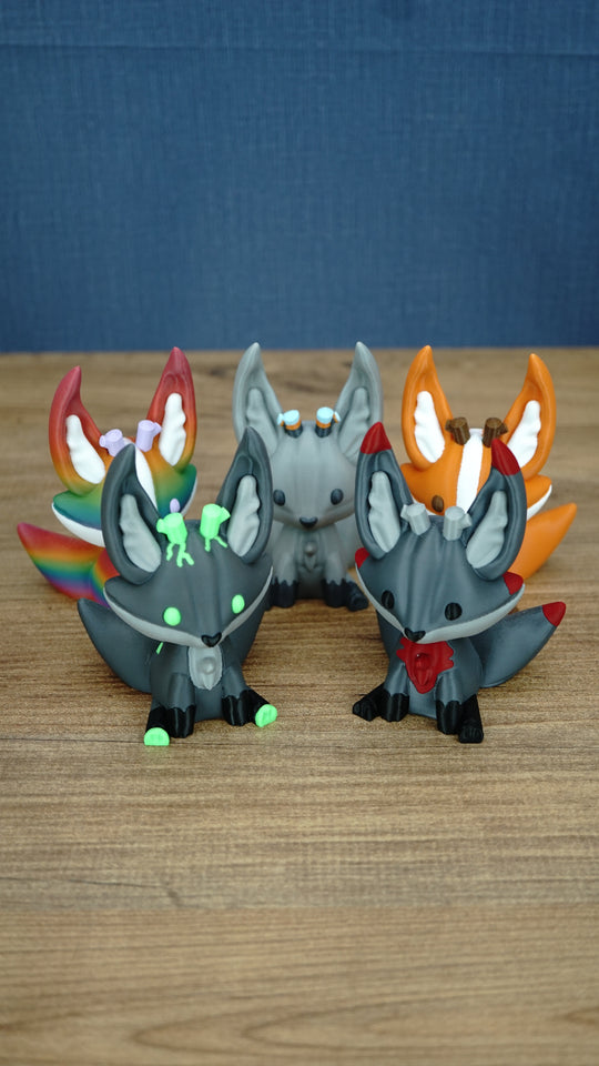 Five Palia Kitsuu 3D printed figures in different variants displayed together on a wooden tabletop.