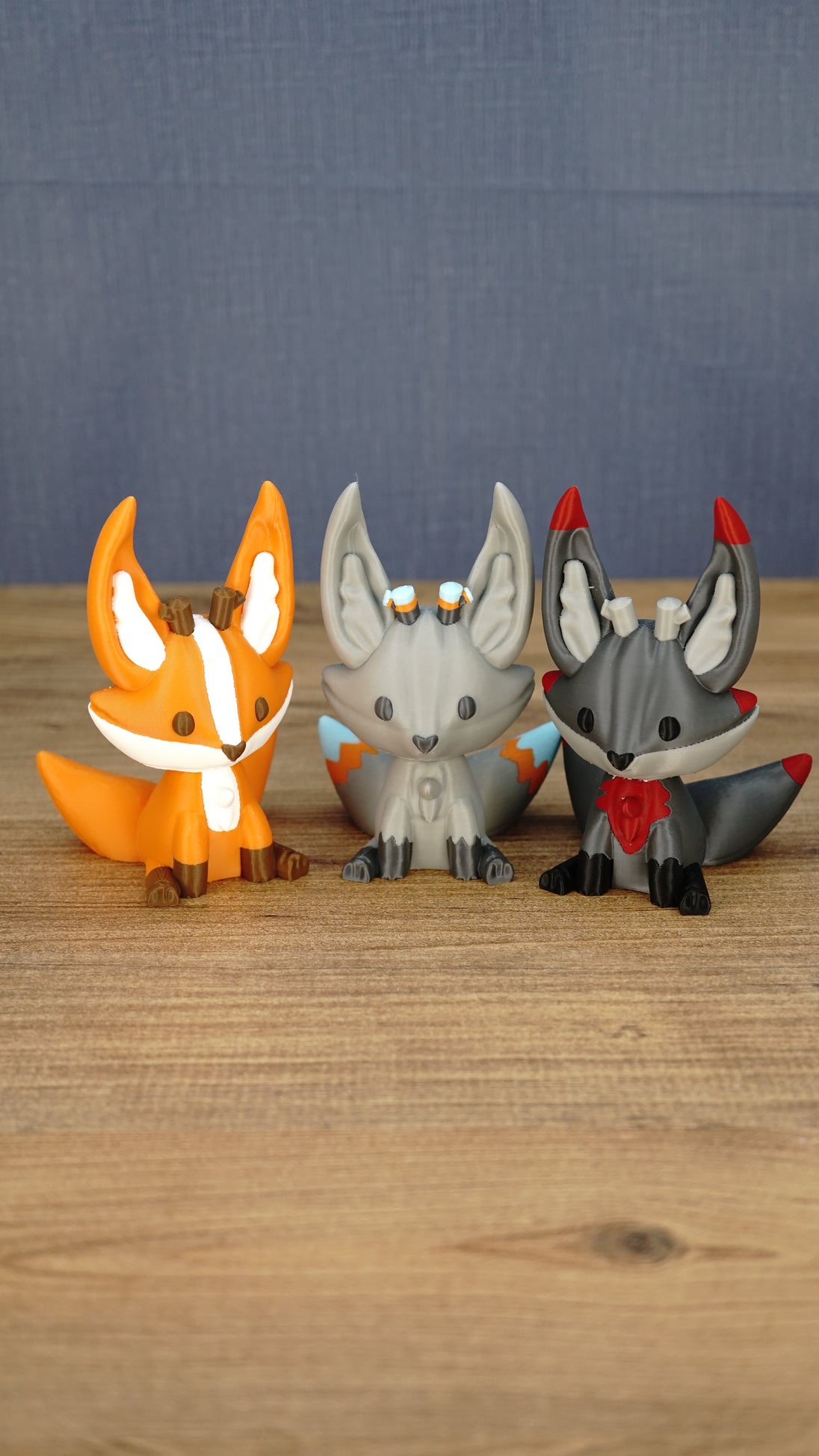 Three Palia Kitsuu plush figure variants displayed together, including orange Ancient Kitsuu, gray Caldera Kitsuu, and dark Shadow Kitsuu styles.