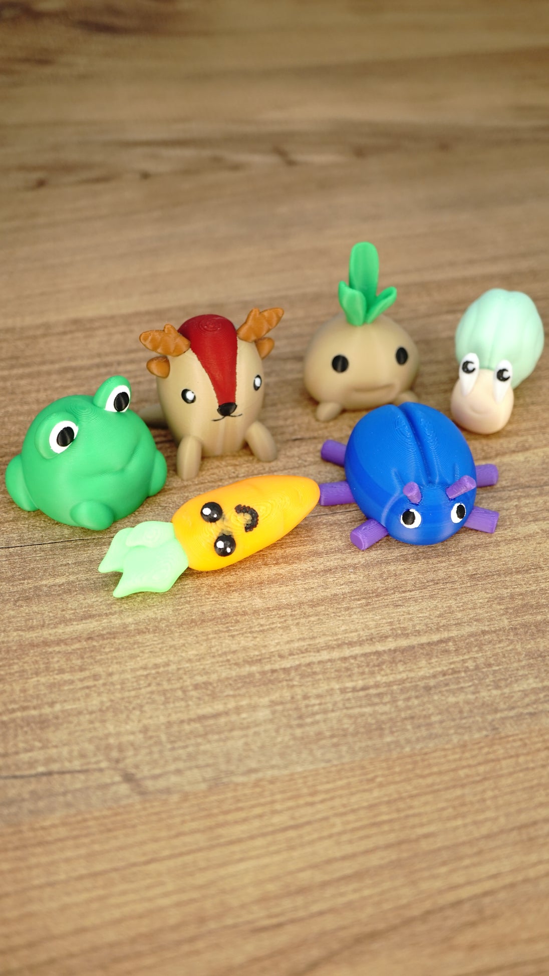 Angled view of six Palia-inspired Li’l Plushies miniatures featuring Li’l Froggy, Sernuk, Turnip, Snail, Carrot and Beetle.