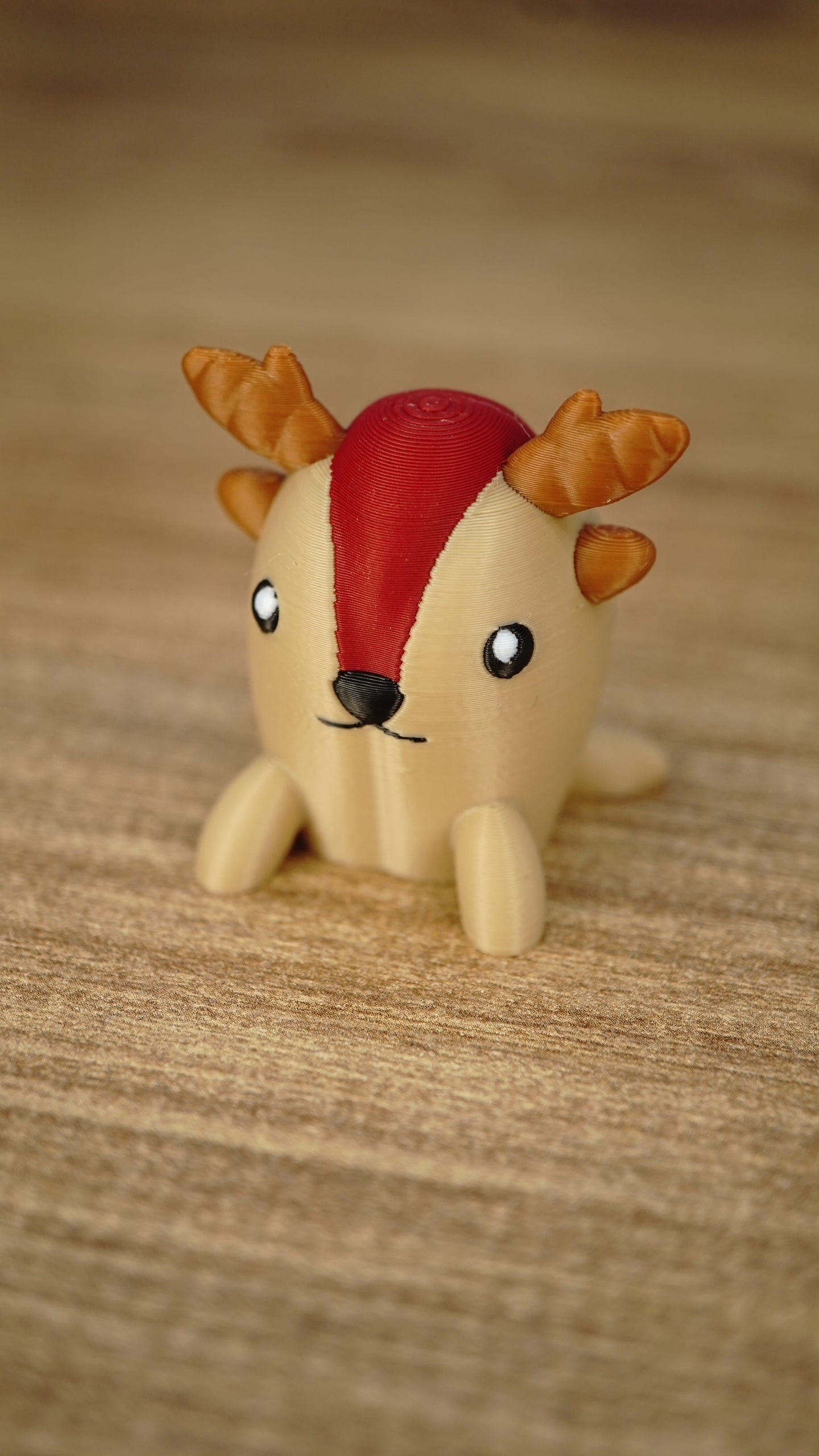 Close-up of the Li’l Sernuk collectible miniature with a tan body, red forehead stripe, brown antlers and a sweet painted face.