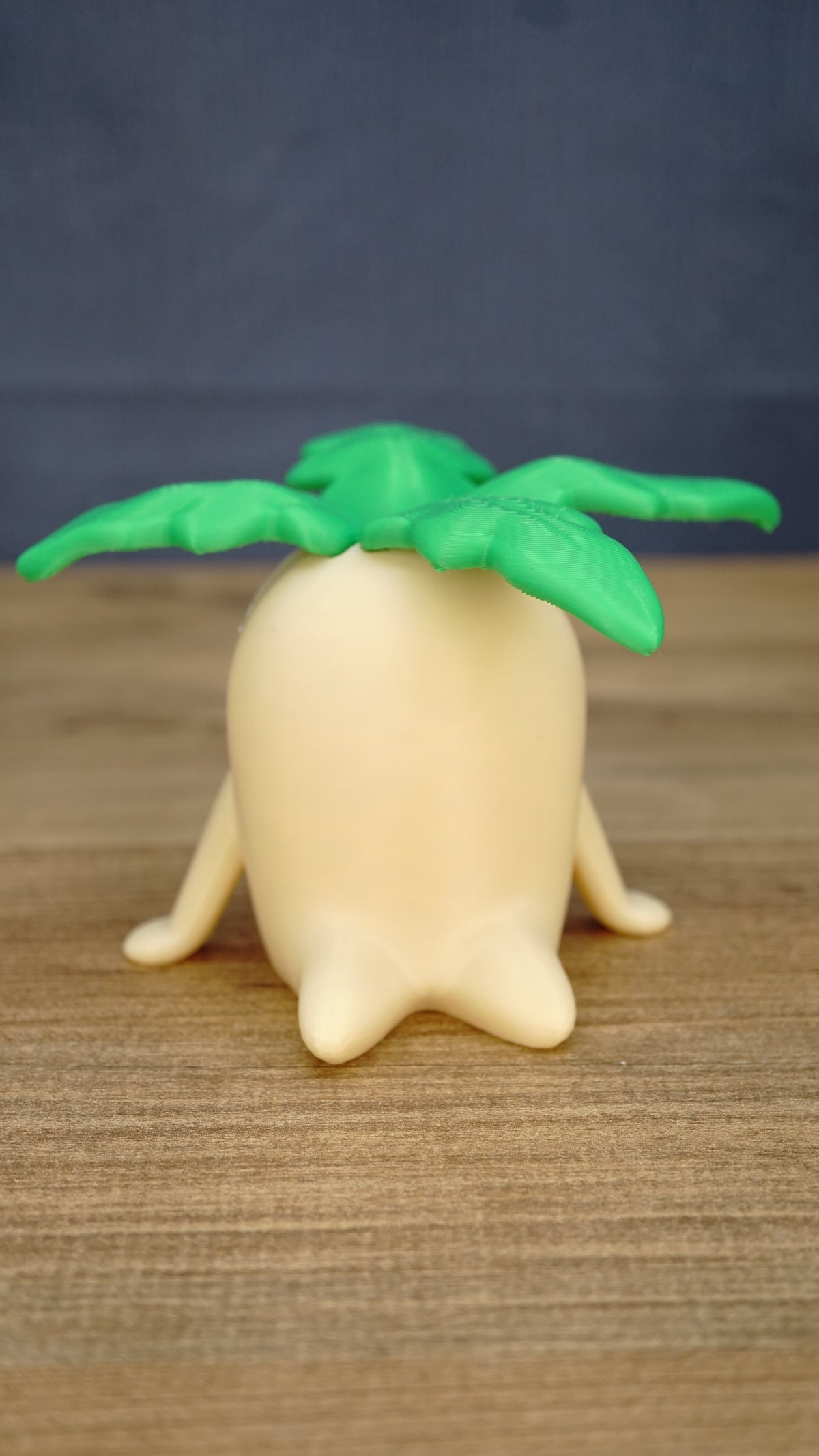 Front view of the large Palia Lil Sprout collectible figure with a rounded cream body, small side legs and wide bright green leafy sprout top.