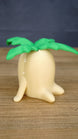 Side view of the large Palia Lil Sprout fan-made collectible showing the rounded cream body, little feet and layered green leaves on top.